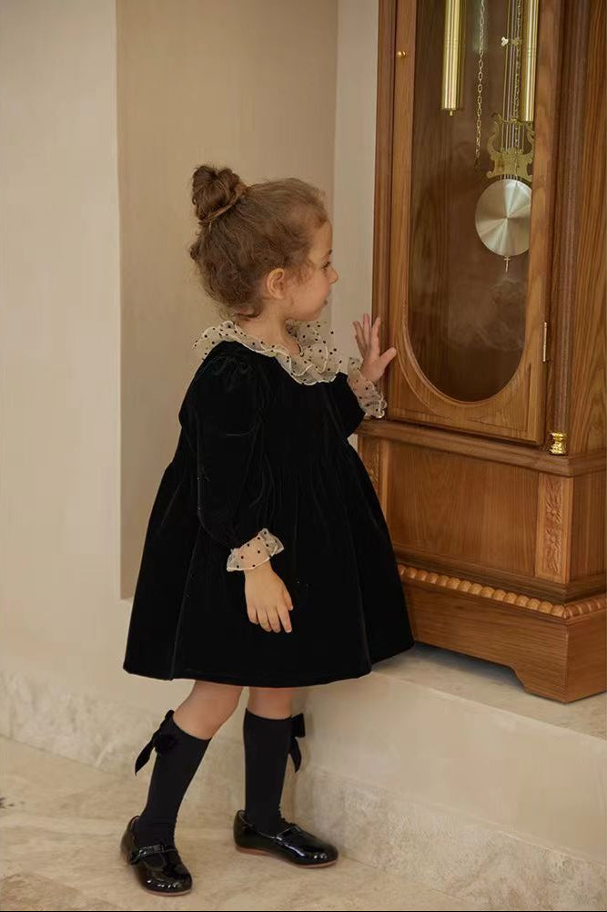 Side view of baby girl wearing black velvet long sleeve dress with polka dot collar – beekaaboo.com