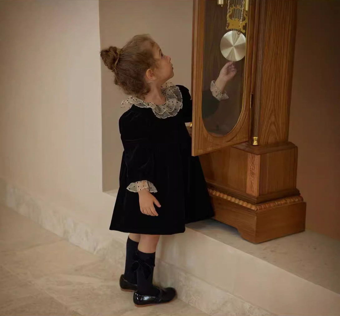 Side view of baby girl wearing black velvet long sleeve dress with polka dot collar – beekaaboo.com