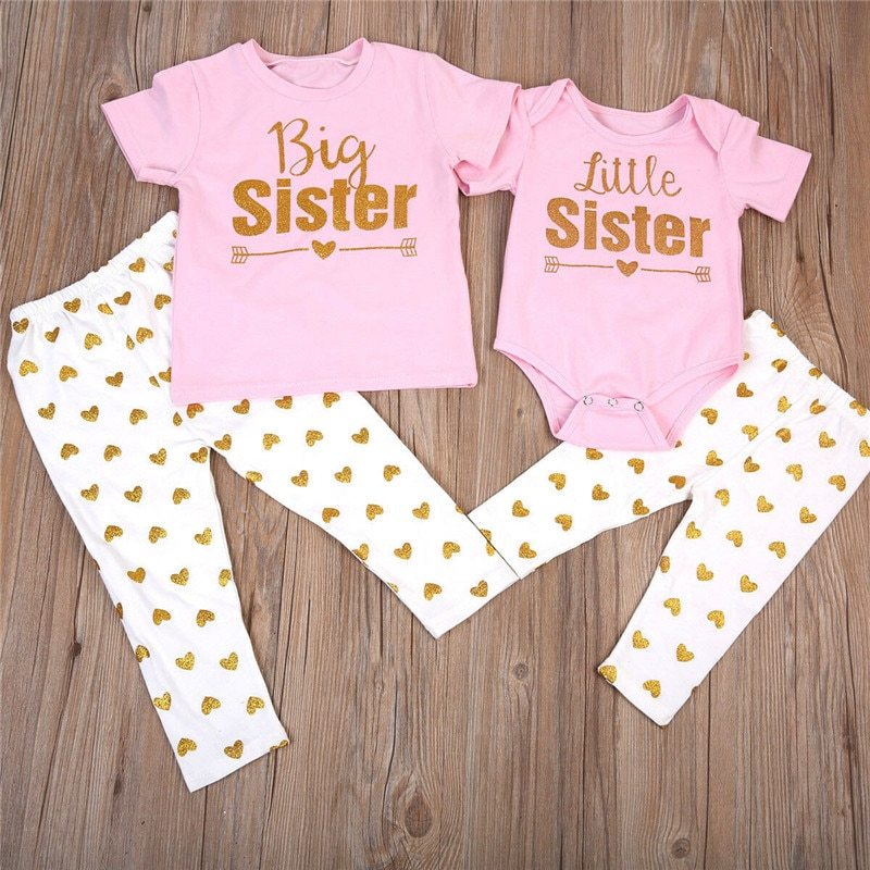 Flat lay of Big Sister T-shirt and Little Sister romper outfit set with pants – cotton sibling clothing – beekaaboo.com