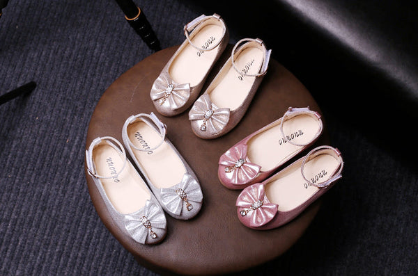 Display of glittery PU ballerina flats for girls in gold, pink, and silver, featuring sparkling bows and gemstone detail – beekaaboo.com