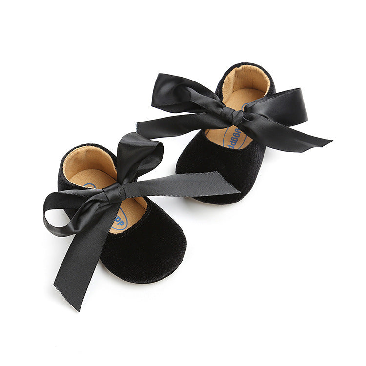 Elegant black baby girl shoes with ribbon ties and soft soles, ideal for formal or casual wear. Available at beekaaboo.com.