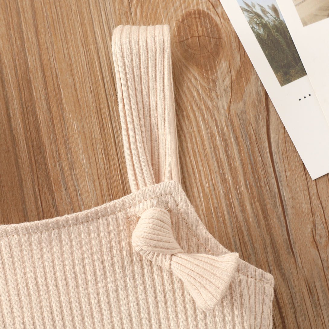 Beige sleeveless baby romper styled flat with soft cotton fabric and hidden closure – beekaaboo.com