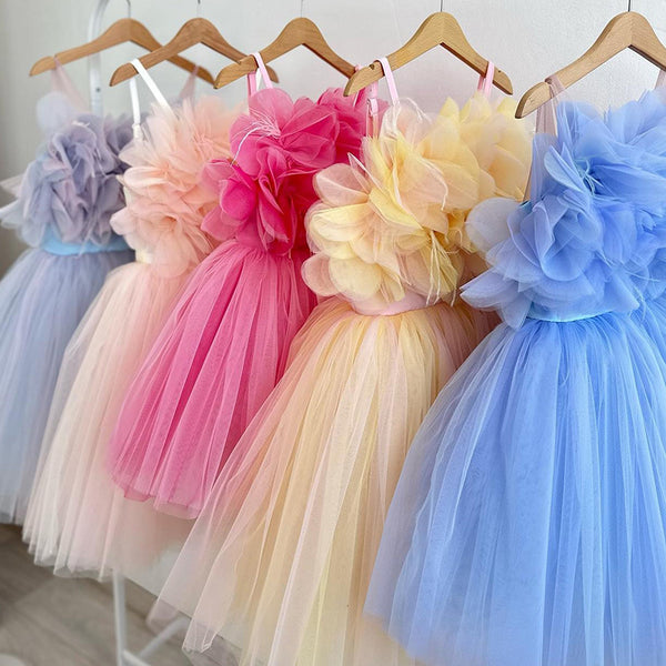Elegant wedding children’s princess dresses in white, pink, rose red, blue, and light blue hanging on a rack – beekaaboo.com