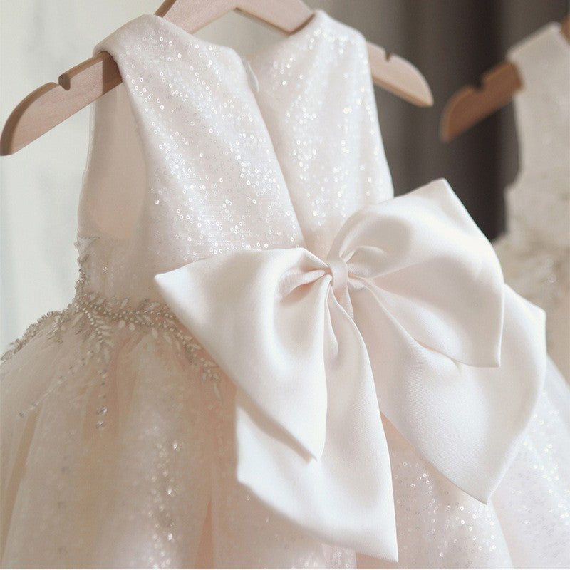 Back view of white girls' dress featuring oversized decorative bow – perfect for formal events – beekaaboo.com