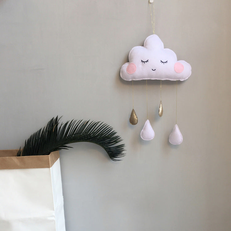 White felt cloud ornament with raindrop accents hanging in a cozy nursery corner – minimalist plush decor – beekaaboo.com
