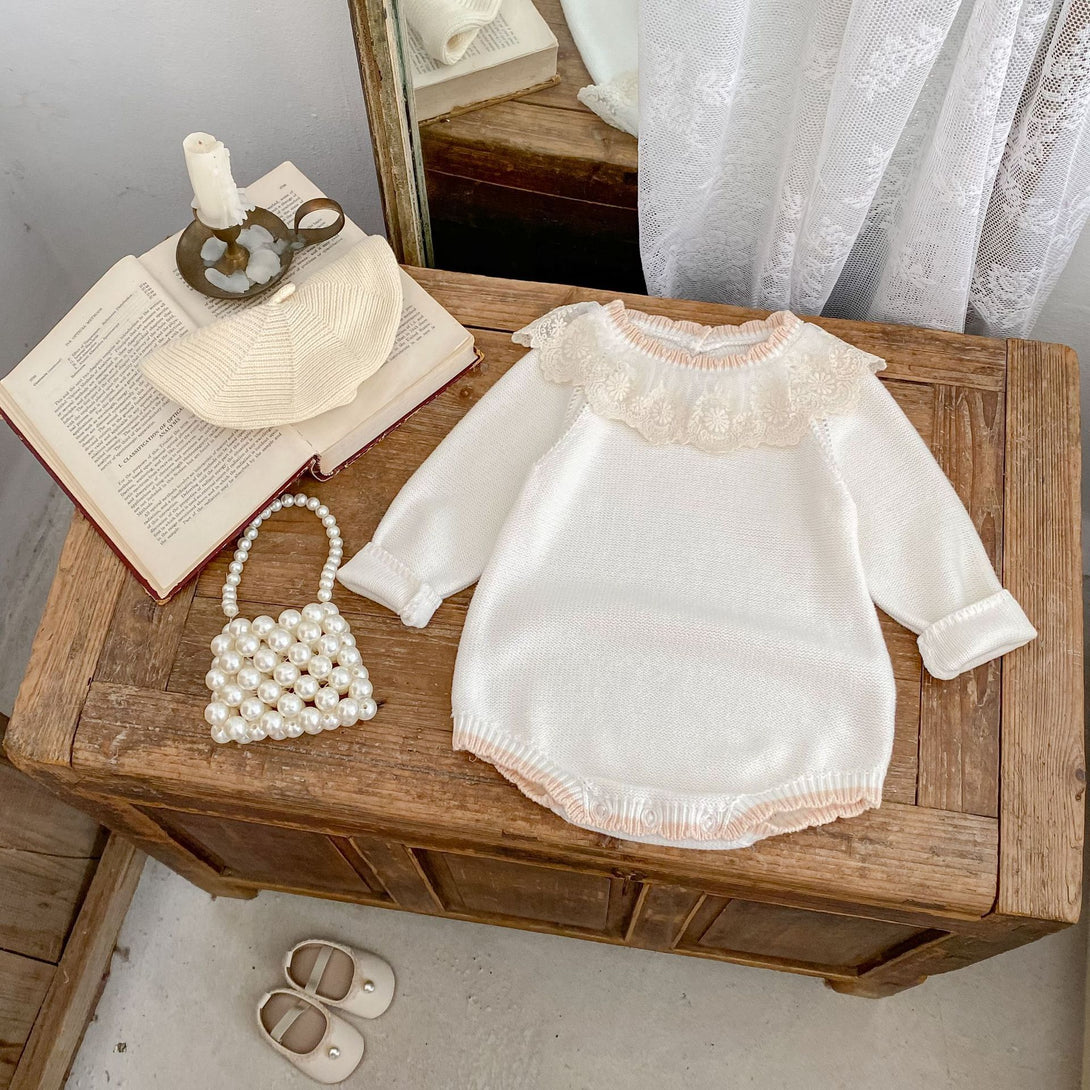 White lace dress on a wooden table with a book, hat, and pearl-handled bag | beekaaboo.com