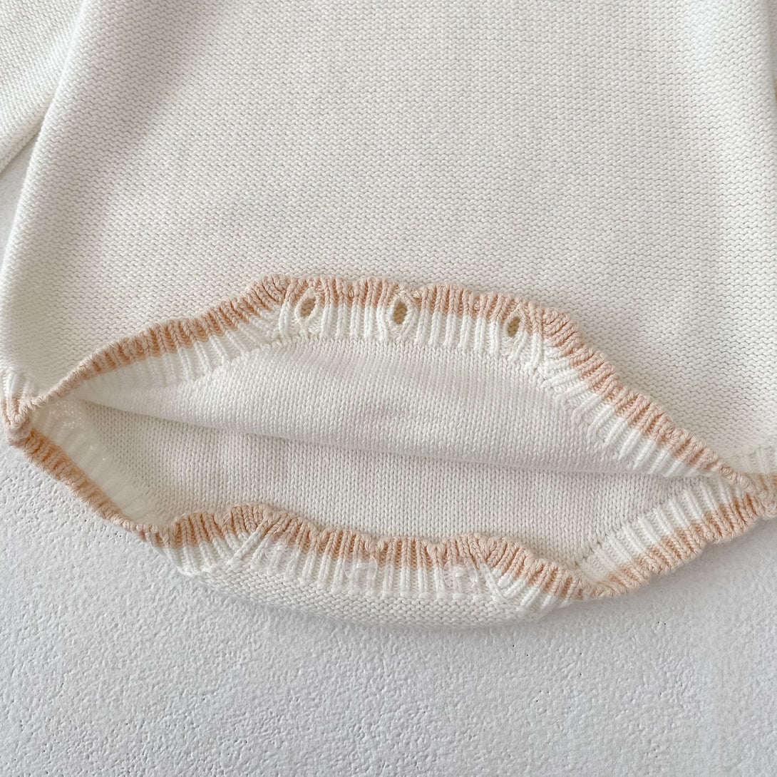 Close-up of knitted baby romper hem in off white cotton | beekaaboo.com