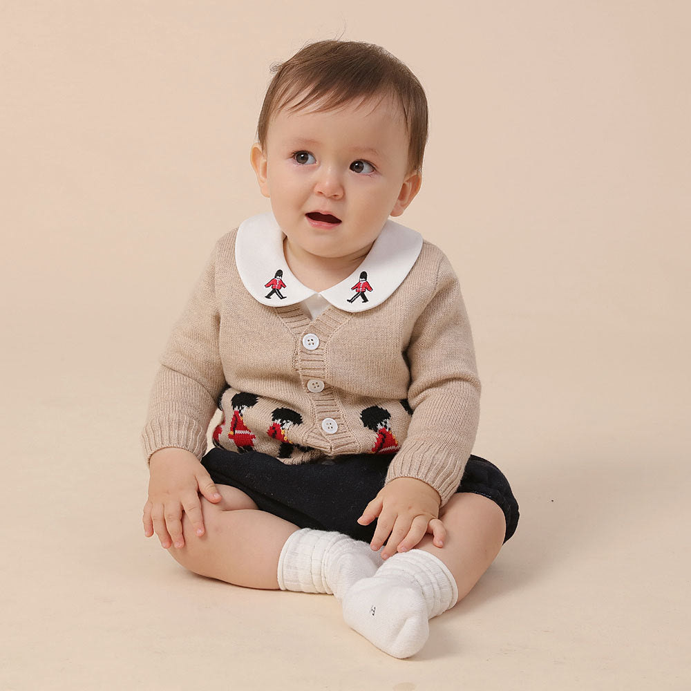 Baby wearing beige cardigan with red guard embroidery – BeeKaaBoo.com