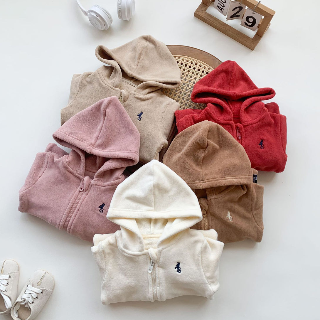 Folded fleece rompers in neutral colors on a woven tray – soft and cozy fabric – beekaaboo.com
