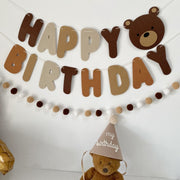 Teddy bear birthday banner decoration in soft brown tones displayed on a wall for a cozy party setup beekaaboo.com