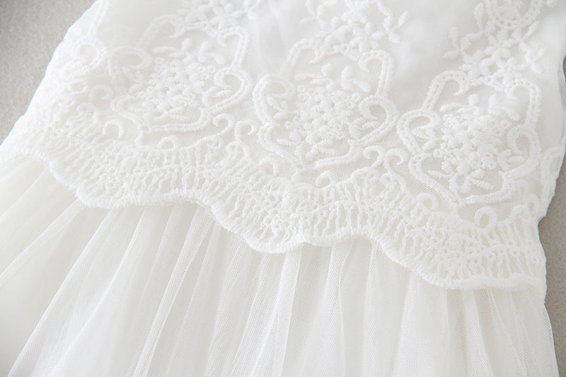 Close-up of embroidered floral lace and fabric texture on baby’s formal white dress – beekaaboo.com